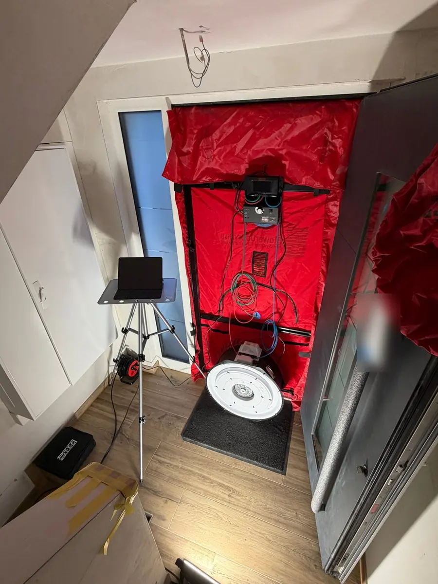 Messaufbau beim Blower-Door-Test mit Gebläse, Druckmessgerät und Tablet